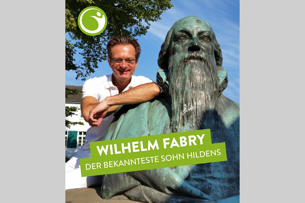 Chiropraktiker in Hilden neben Wilhelm Fabry Statue bei strahlendem Sonnenschein.