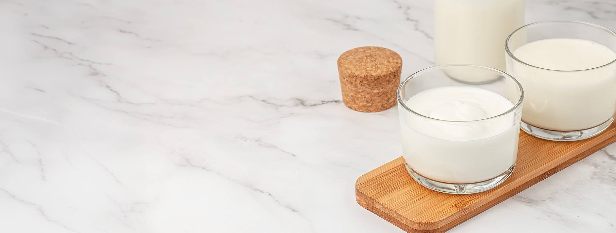 Gläser mit Joghurt auf Holzbrett, Ernährungsberatung in Hilden und Düsseldorf.